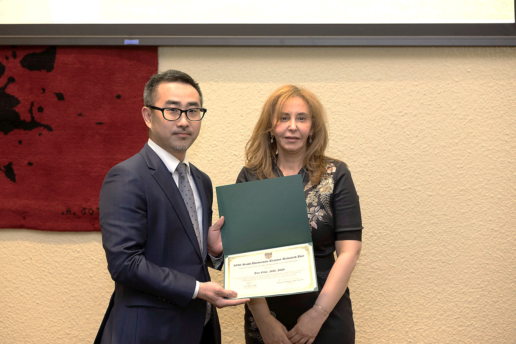 Jun Oike receiving the Oral Presentation Award