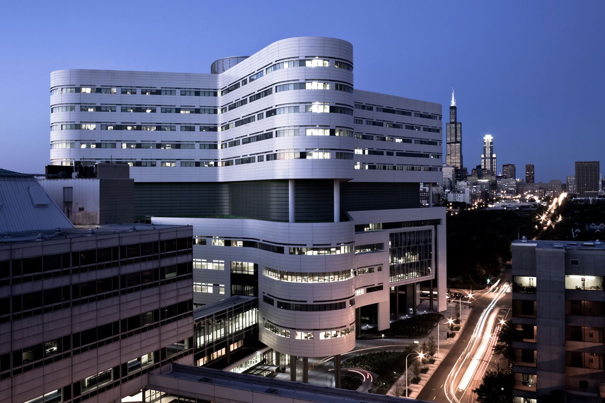 Rush University Medical Center at dusk with the Willis Tower rising in the Chicago skyline beyond